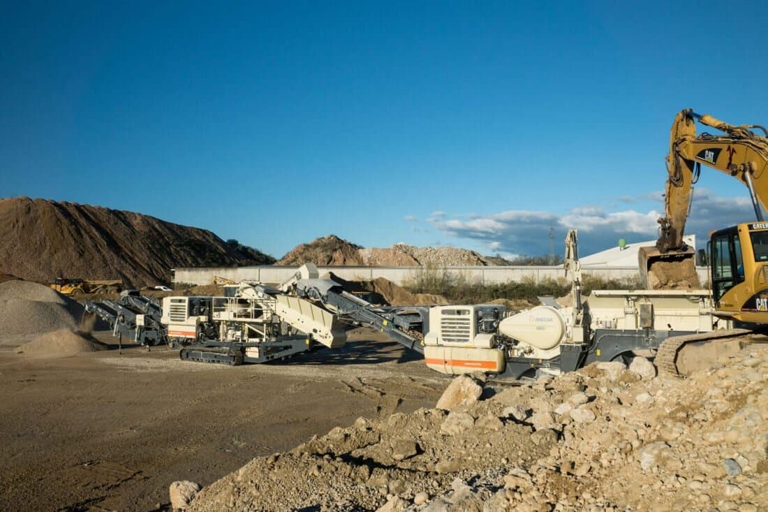 Mobile Brecheranlage im Steinbruch mit Bagger