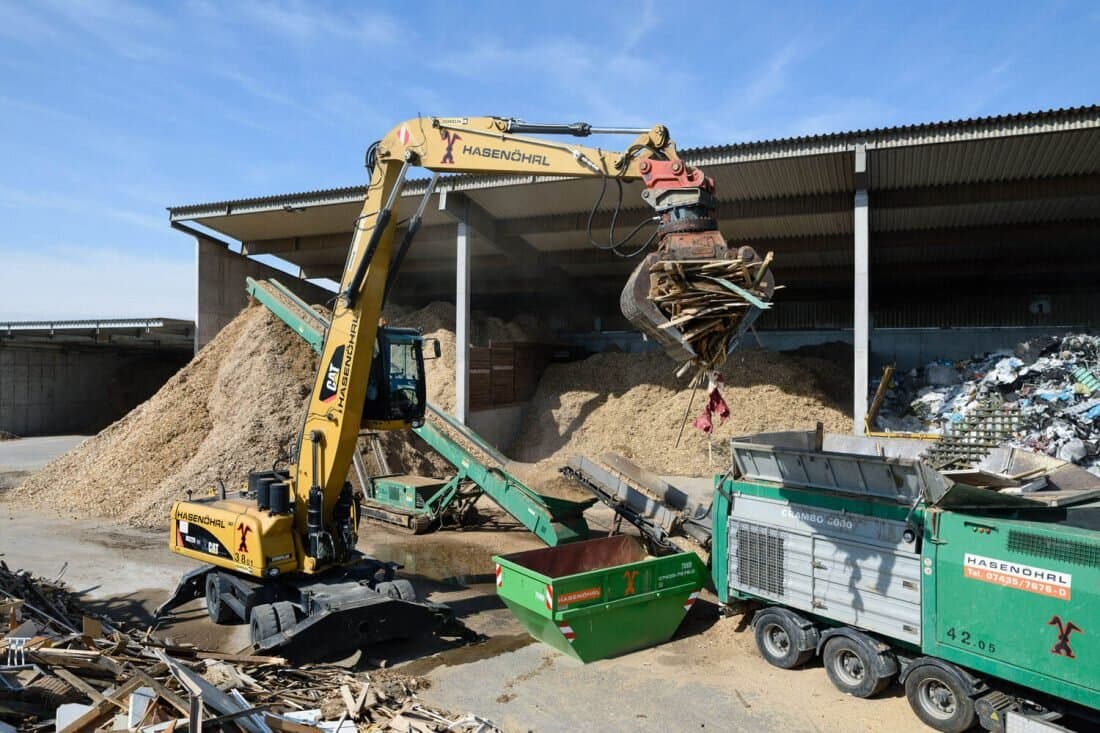 Bagger sortiert Bauschutt in der Recyclinghalle